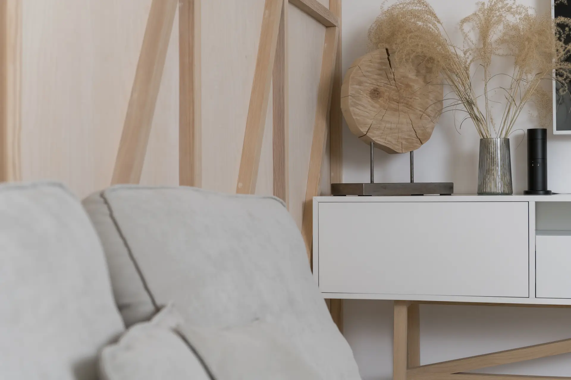 Detalj av minimalistisk skjenk med naturlige tørkede vekster og skandinavisk keramikk